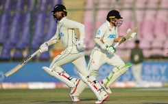 New Zealand's Devon Conway (L) and Tom Latham run between the wickets during the second day of the first cricket Test match between Pakistan and New Zealand at the National Stadium in Karachi