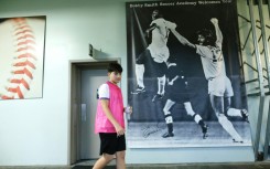 A young athlete walks past a poster showing Pele and defender Robert "Bobby" Smith at a sports academy now run by Smith in New Jersey 