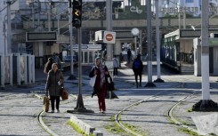 Tunisians are pictured next to a tram station in the capital Tunis during a public transport employee strike on Monday