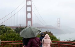 People visit the Golden Gate Bridge as a rain storm moves through the San Francisco area on January 04, 2023