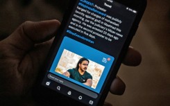 A person in the Cypriot capital Nicosia checks a mobile phone displaying a tweet about the execution of Majidreza Rahnavard