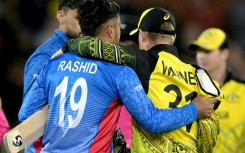 Australia's David Warner (R) embraces Afghanistan's Rashid Khan