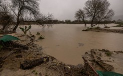 This aerial view shows two cars siting in a large sinkhole that opened during a day of relentless rain, January 10, 2023 in the Chatsworth neighborhood of Los Angeles, California