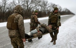 Ukraine army medics evacuate a wounded soldier on a road not far of Soledar on Saturday