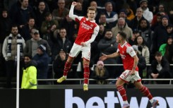 Soaring clear: Martin Odegaard (centre) scored as Arsenal moved eight points clear at the top of the Premier League