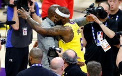 LeBron James, at center right, celebrates with retired Los Angeles Lakers legend Magic Johnson, center left, after James overtook Kareem Abdul-Jabbar to become the NBA's all-time leading scorer
