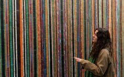 A woman looks at artwork by Algerian-born French artist Adel Abdessemed at the Zona Maco fair in Mexico City