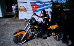 A Cuban biker on an orange Harley-Davidson tricycle takes part in a meeting for enthusiasts in Varadero, Cuba