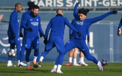 Kylian Mbappe stretching for the ball in training watched  by Lionel Messi