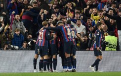 Barcelona's Brazilian forward Raphinha celebrates with teammates after scoring his team's second goal against Man United