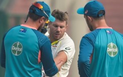 Australia's David Warner gets treatment on his elbow during the opening day of the second Test against India in Delhi