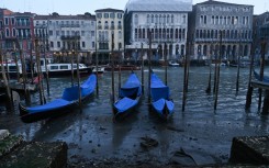 Tourists out on the deeper, busier canals sailed past exposed foundations of ancient palazzos in the UNESCO World Heritage Site