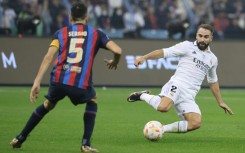 Barcelona's Spanish midfielder Sergio Busquets (L) fights for the ball with Real Madrid defender Dani Carvajal