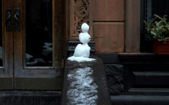 A small snowman sits on a stoop on New York's West Side on February 28, 2023