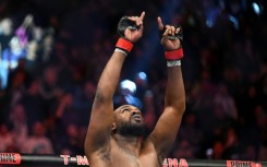 Jon Jones celebrates after routing France's Ciryl Gane to win the vacant UFC heavyweight crown