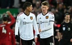 Manchester United's Raphael Varane (L) and Scott McTominay react to their historic defeat at Liverpool