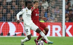 Real Madrid's French midfielder Eduardo Camavinga (L) vies with Liverpool's Roberto Firmino