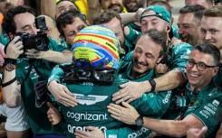 Fernando Alonso is embraced by his pit crew after finishing third before stewards ruled one of them had got too close during the race, only to later withdraw the charge
