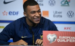 Kylian Mbappe smiles as he speaks to media at the Stade de France on Thursday ahead of France's Euro 2024 qualifier against the Netherlands
