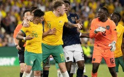 Alex Robertson (left) is protected by teammate Harry Souttar during a scuffle against Ecuador