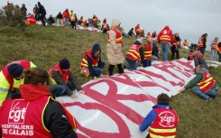They battled clifftop winds to unfurl the banner so it could be easily seen from the coast