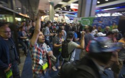 People rush into an exhibit hall on opening day of the Electronic Entertainment Expo (E3) at the Los Angeles Convention Center in June 2017