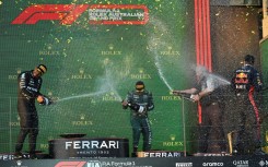 Red Bull's Max Verstappen (R) celebrates with Lewis Hamilton of Mercedes (L) and Aston Martin's Fernando Alonso (C)
