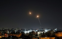 Streaks of light are seen in the sky as Israeli air defences intercept rocket fire from the Gaza Strip