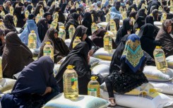 Afghan women receiving food aid distributed by a charity in Herat during the Islamic holy month of Ramadan