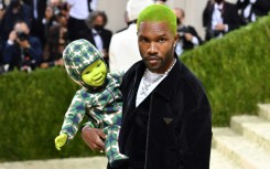 US singer-songwriter Frank Ocean holds a robot baby as he arrives for the Met Gala in September 2021 in New York