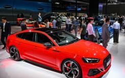People visit a booth at the Shanghai Auto Show