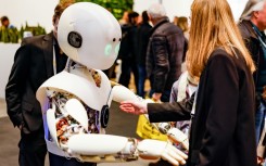 A woman interacts with a robot at a major trade fair in Hanover