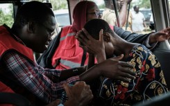 A member of the Kenya Red Cross comforts a rescued follower of the Good News International Church
