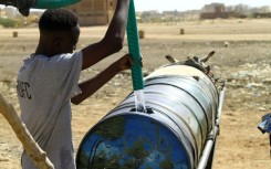 A man fills water into a barrel mounted on donkey-pulled carts in southern Khartoum on April 22, 2023, amid water shortages caused by the ongoing battles between the forces of two rival Sudanese generals