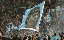 Napoli fans waving a giant flag of Diego Maradona, who led the club to their first two titles
