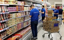 Employees of the Carrefour Hypermarket in Raanana, Israel, stock shelves before the French firm's opening in the country