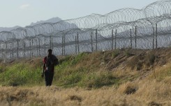 A migrant walks along the banks of the Rio Grande river to surrender to US border agents from El Paso, Texas