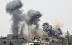 Smoke rises above buildings in Rafah in the southern Gaza Strip following an Israeli strike on May 12, 2023