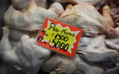 Chickens are seen with a sign indicating their price in Argentine pesos at the Central Market in Buenos Aires on May 12, 2023