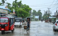 A man rides a bicycle in an almost empty street in Kyauktaw in Myanmar on May 14, 2023, ahead of the expected landfall of Cyclone Mocha