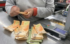 A cashier counts Argentine peso bills at a supermarket in Buenos Aires