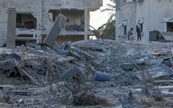 Palestinians inspect the rubble of a residential building destroyed by an Israeli air strike in Deir al-Balah in the central Gaza Strip