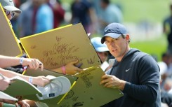 Four-time major winner Rory McIlroy of Northern Ireland signs an autograph at Oak Hill ahead of the PGA Championship