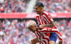 Atletico Madrid forward Angel Correa (top) celebrates with Antoine Griezmann after scoring his team's third goal against Osasuna