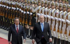 Russian Prime Minister Mikhail Mishustin (R) and Chinese Premier Li Qiang attend a welcoming ceremony in Beijing on May 24, 2023