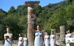 Greek actress Xanthi Georgiou, playing the role of the High Priestess, holds up the lit torch before the flame started its journey to Beijing for the 2022 Winter Games