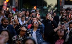 People use their phones to snap pictures of the phenomenon known here as Manhattanhenge

