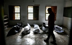 Bodies are laid out at a high school used as temporary mortuary to identify the dead recovered from the carriage wreckage