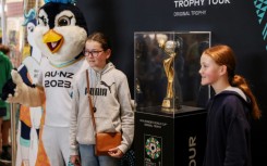 People pose with the trophy for the Women's World Cup at a shopping mall in Auckland