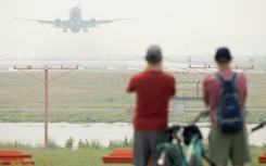 An airliner takes off through the haze from Ronald Reagan Washington National Airport on June 8, 2023